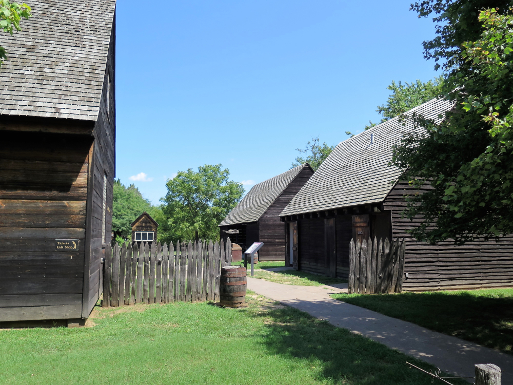 old log buildings at tourist attraction, clear sky and walkway between the buildings