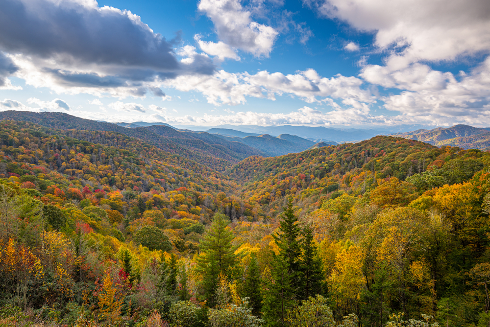 aerial image of the great smoky mountains national park with beautiful fall colours and a cloudy blue sky!