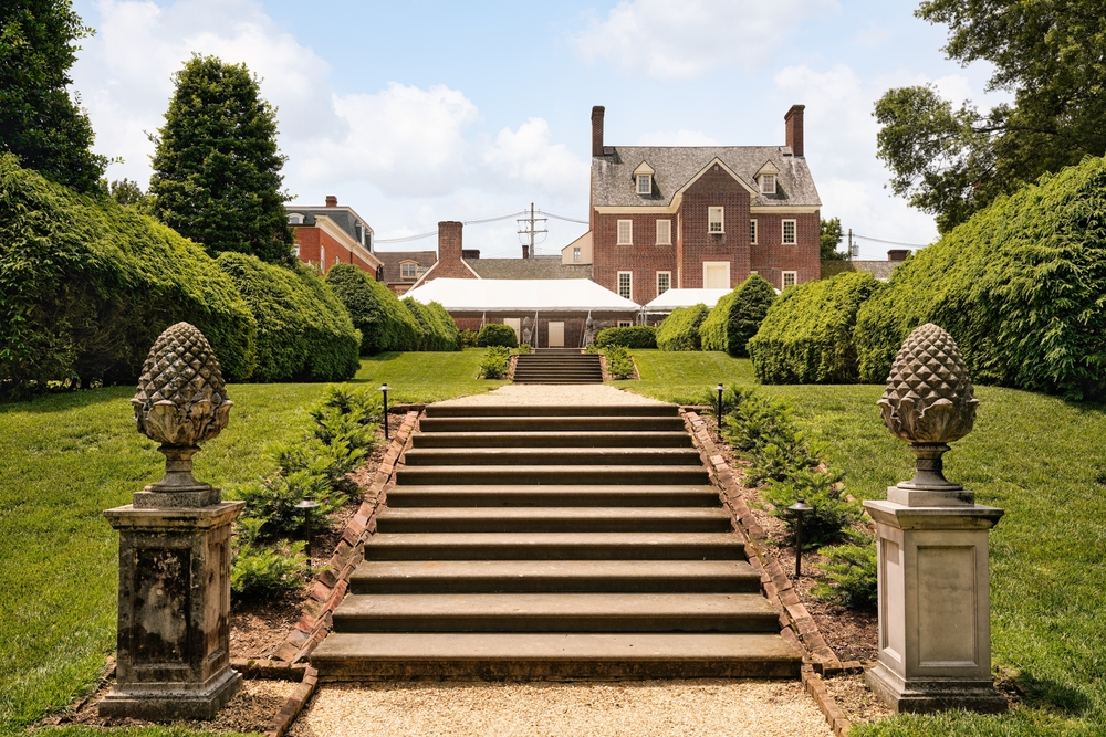 william paca house, one of the best things to do in annapolis, a stair case with multiple levels leads to a brick house, theres grass on both sides of the stairs