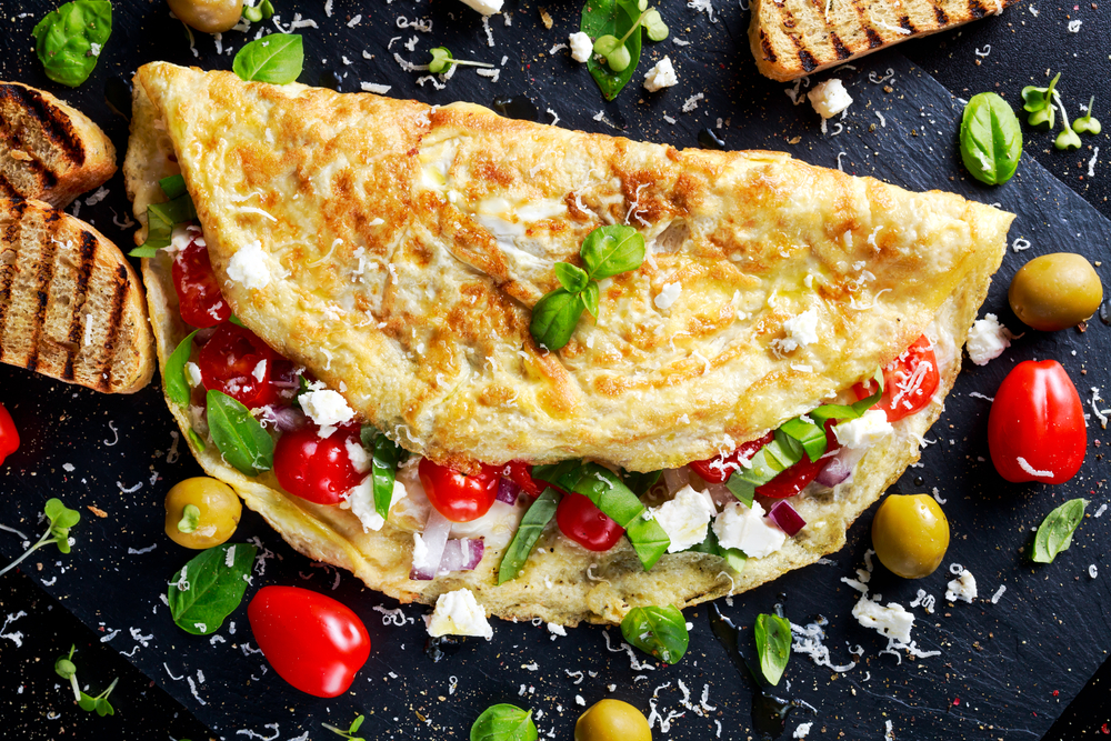 Greek omelette brimming with tomatoes, olives and onion. 
