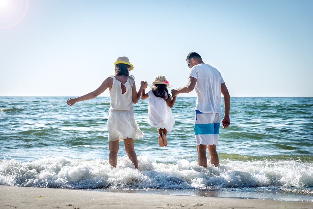 a cute family playing in the water at the beach 