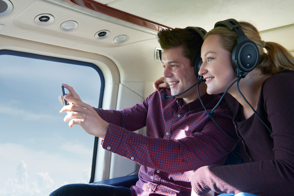 a couple taking photos during a helicopter ride in the inner harbor of Balitmore MD 