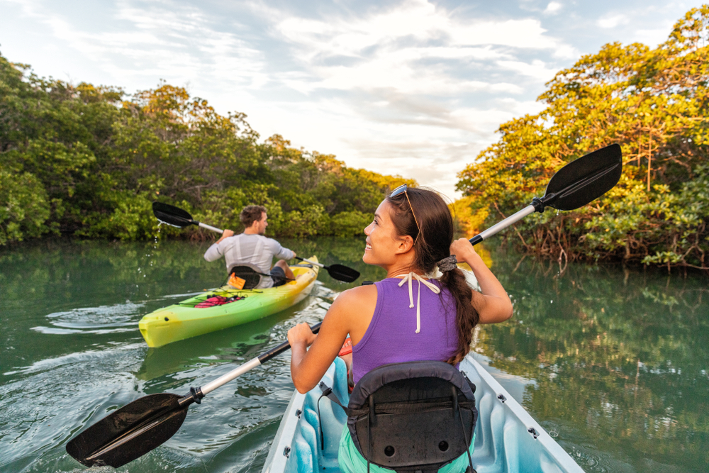 a girl kayaking in the waters of the beaches in Maryland wearing a purple shirt 