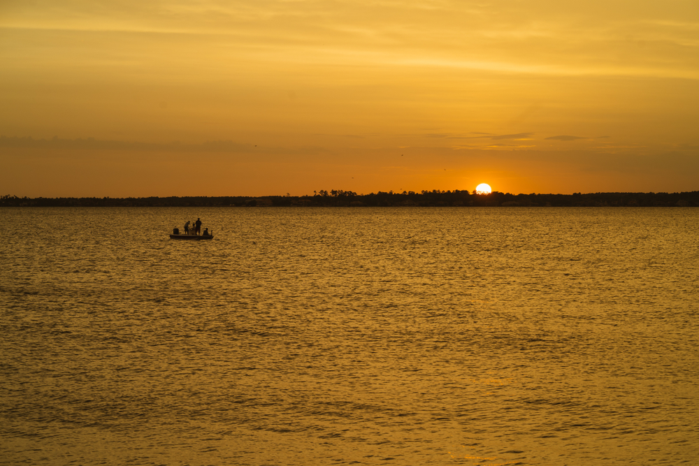 Photo of a boat sailing on Lake Conroe at sunset, one of the coolest things to do in conroe 