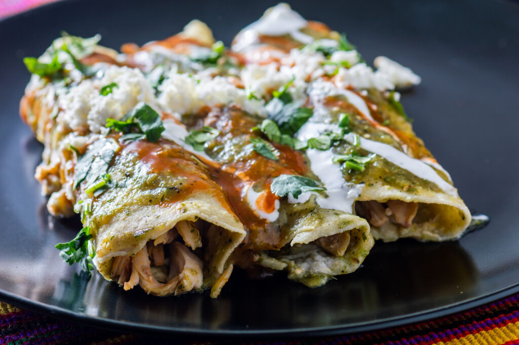 green chicken enchiladas at outdoor brunch in Austin looking delicious with sour cream on top