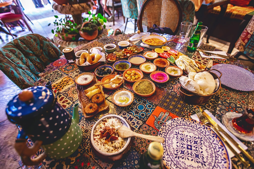 Mediterranean food spread out into many small dishes across a colorful table 