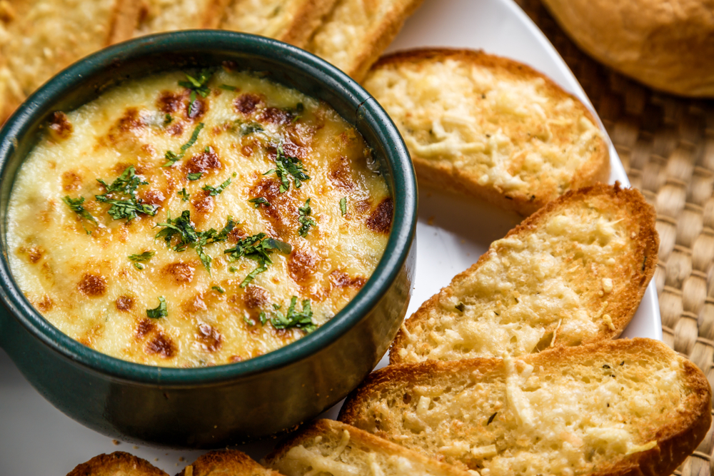 warm crab dip with green herbs on top, cheesy bread surrounds the dip, some of the best brunch in nashville