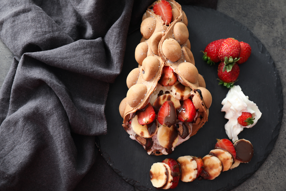 For some of the best brunch in New Orleans, try bubble waffles! This photo shows a bubble waffled stuffed with bananas, strawberries and chocolate.