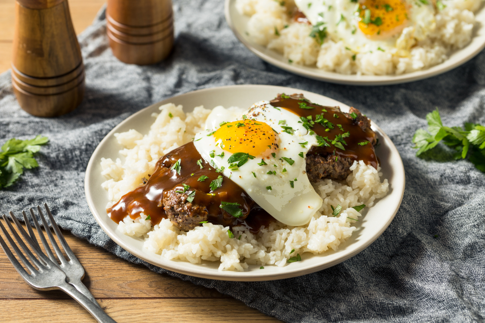 steak and eggs over rice with forks on the side at one of the best brunch locations in Houston