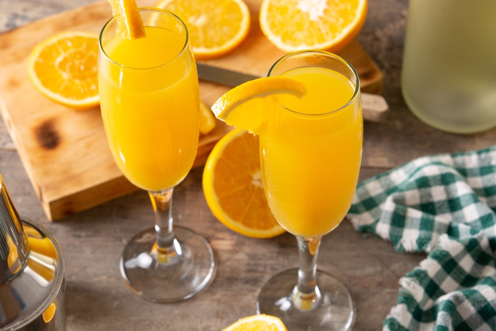 2 glasses of mimosas with orange slices at The Union Kitchen, a great pick for the best brunch in Houston.