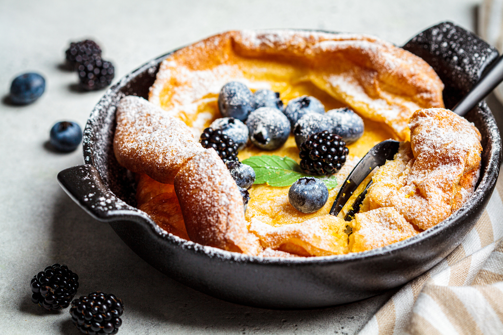 Dutch baby pancake served in a cast iron and covered in berries at Squable. 