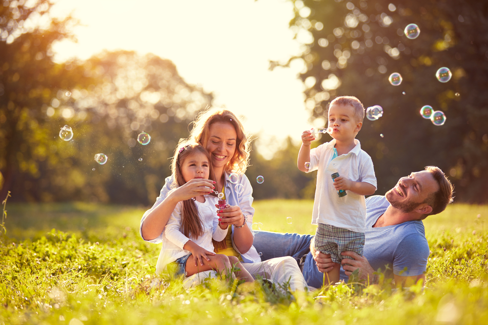 a lovely family enjoying nature together and of course, blowing bubbles together!