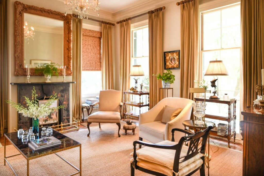 Sunny, elegant lounge room with seats and a fireplace at Catherine Ward House Inn .