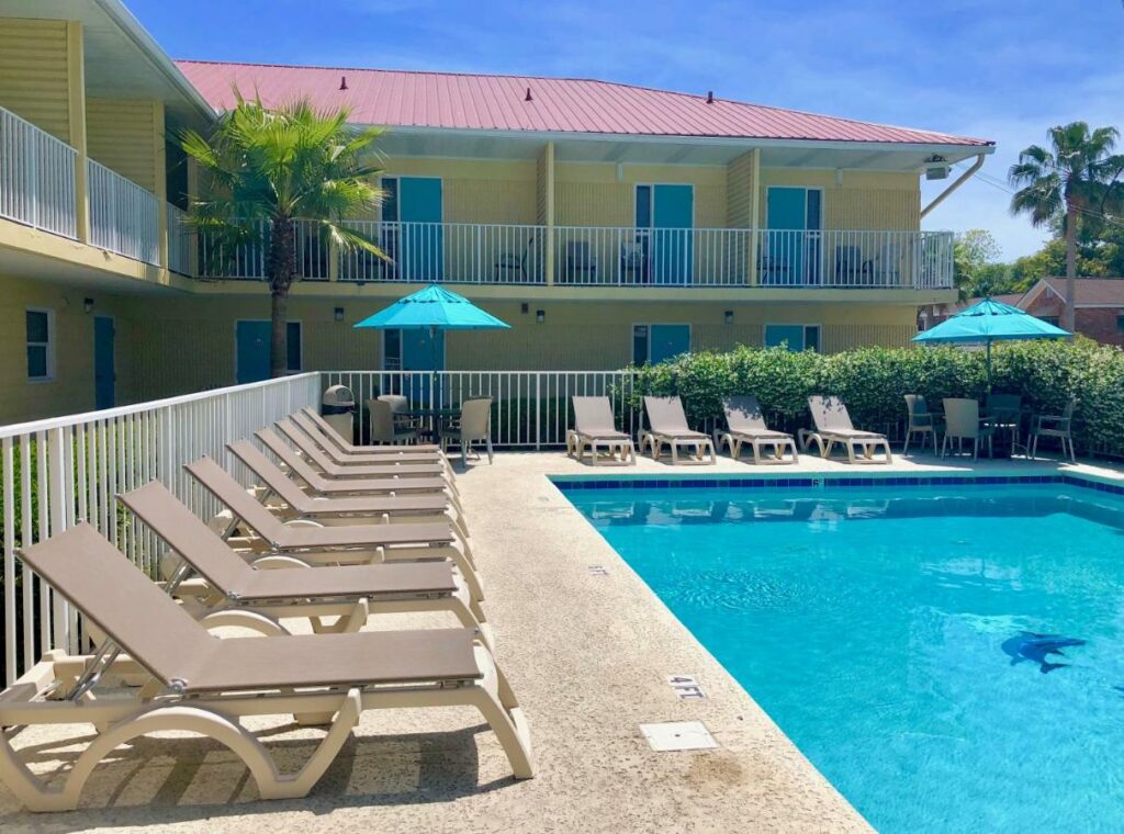 The pool area at the Dunes Inn & Suites with lounge chairs.