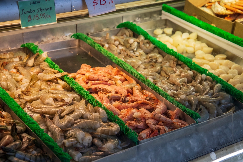 trays of shrimp in a market in atlanta, price tags above the shrimp 