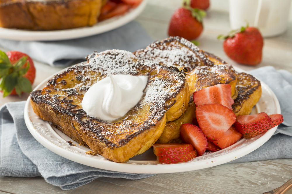 yummy cake like French toast with sugar, strawberries, and whipped cream served at one of the best brunch in Charleston SC 