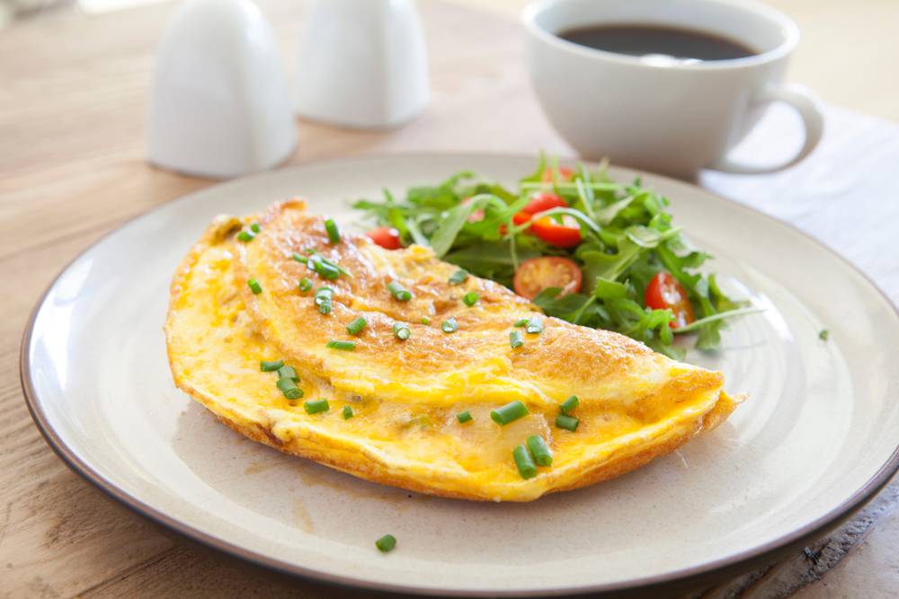 a yummy fresh omelet with a green salad and chives on top 