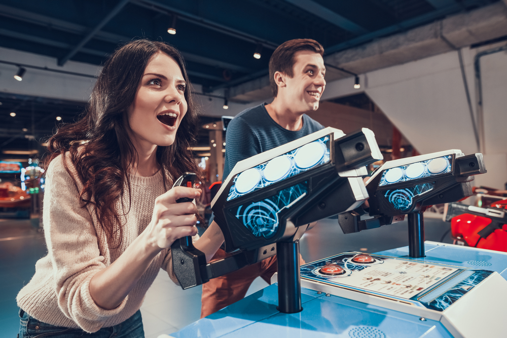 a young couple playing in an arcade. It is one of the best things to do in Dallas for adults 