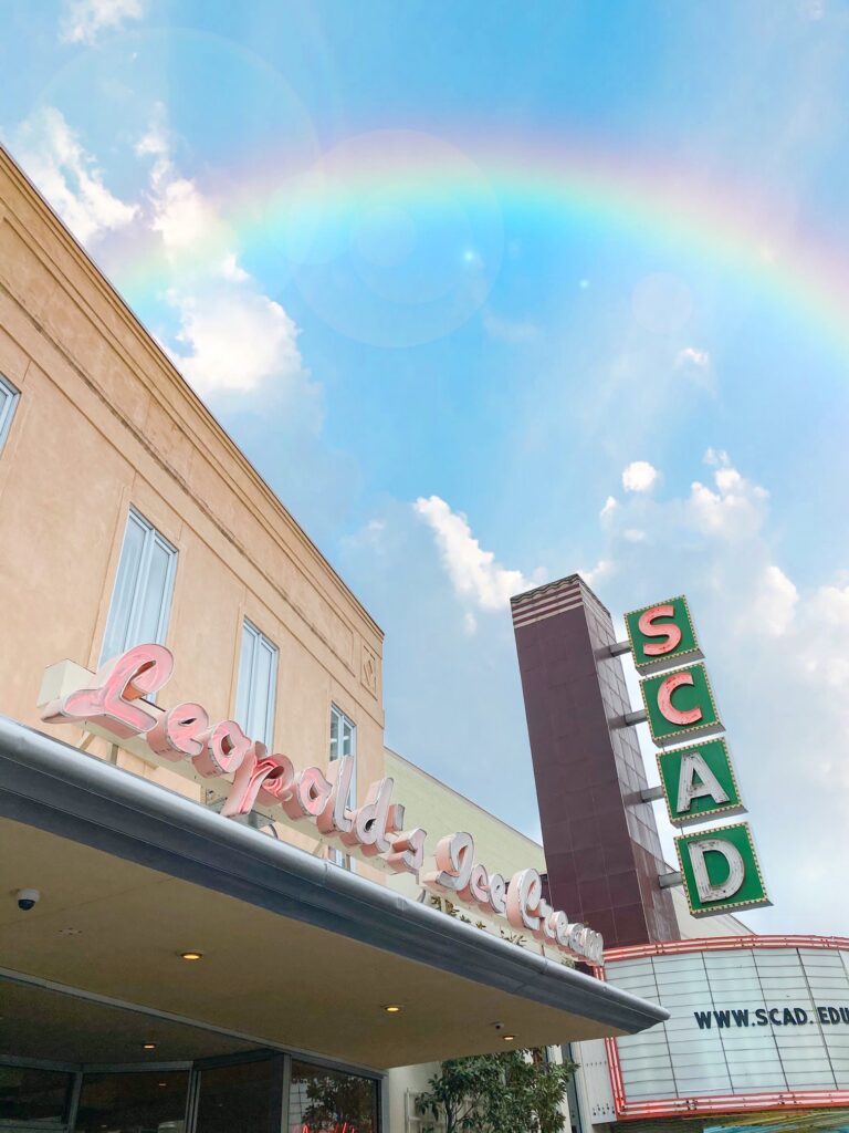 A rainbow over the pink Leopold's Ice Cream sign.