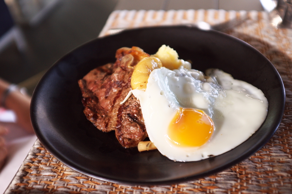 steak and eggs served at a brunch in Charleston on a black plate 