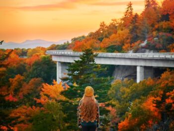 woman standing in front of lynn cove viaduct in the blue ridge mountains NC