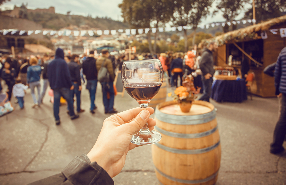 a wine festival with a man holding a red wine glass 