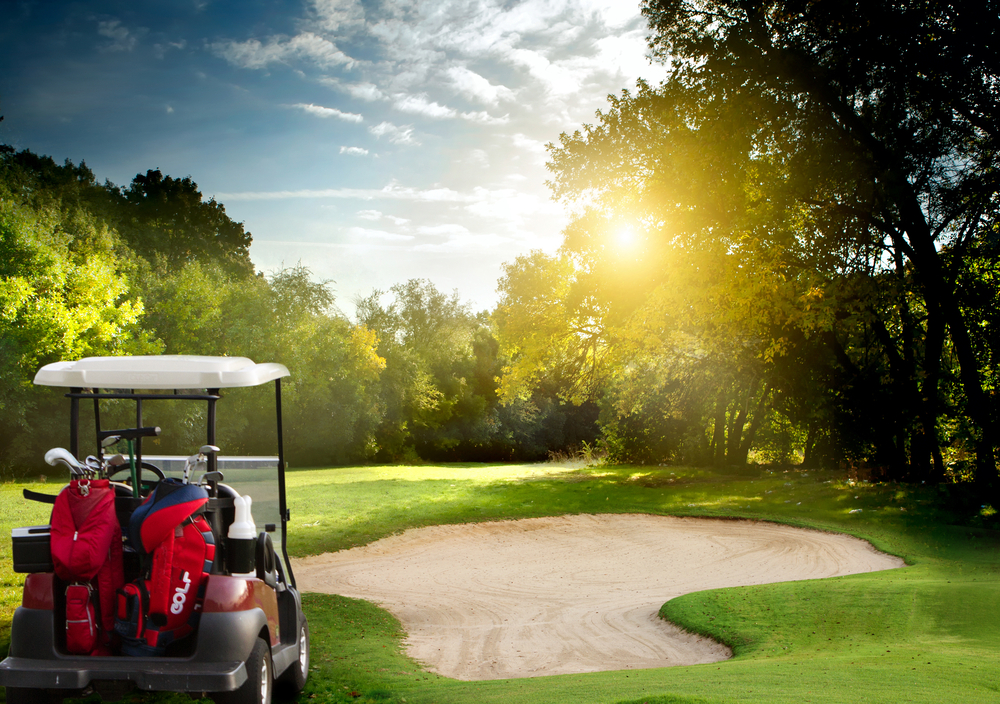 golf cart sitting on the green in Tennessee with sun rays