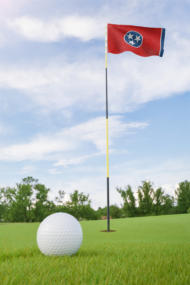 A Tennessee flag marks a hole, with a golf ball in the foreground, at one of the best golf courses in TN.