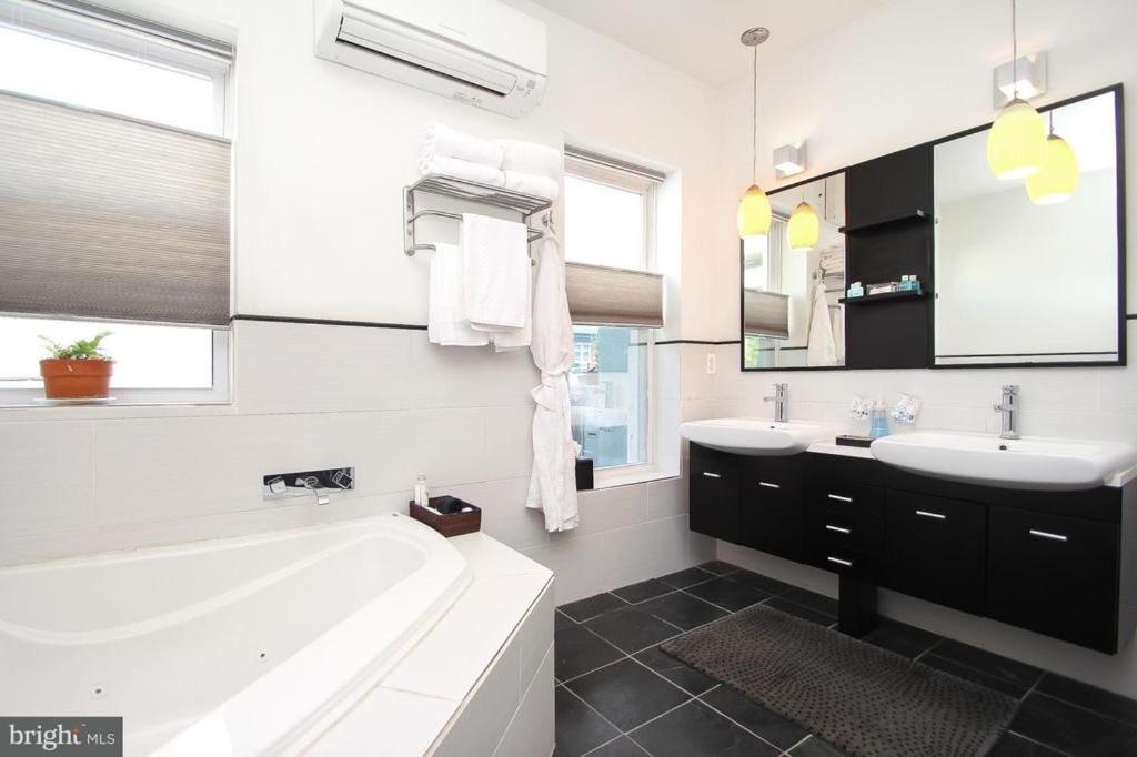 black and white modern bathroom with sleek angles and a deep jacuzzi bathtub!