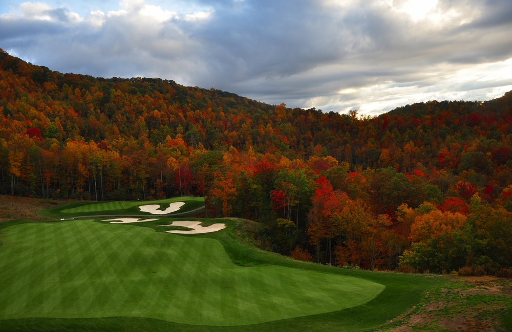Fall trees surrounded a well manicured gollf course with 3 sand traps