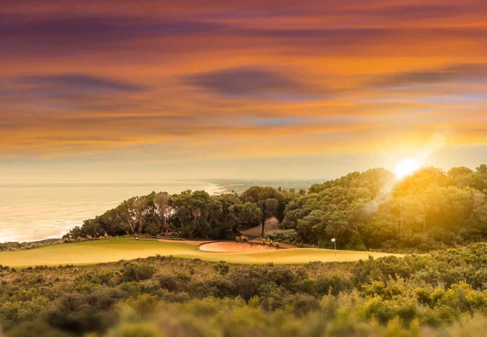 Seaside golf course overlooking the ocean at sunset time