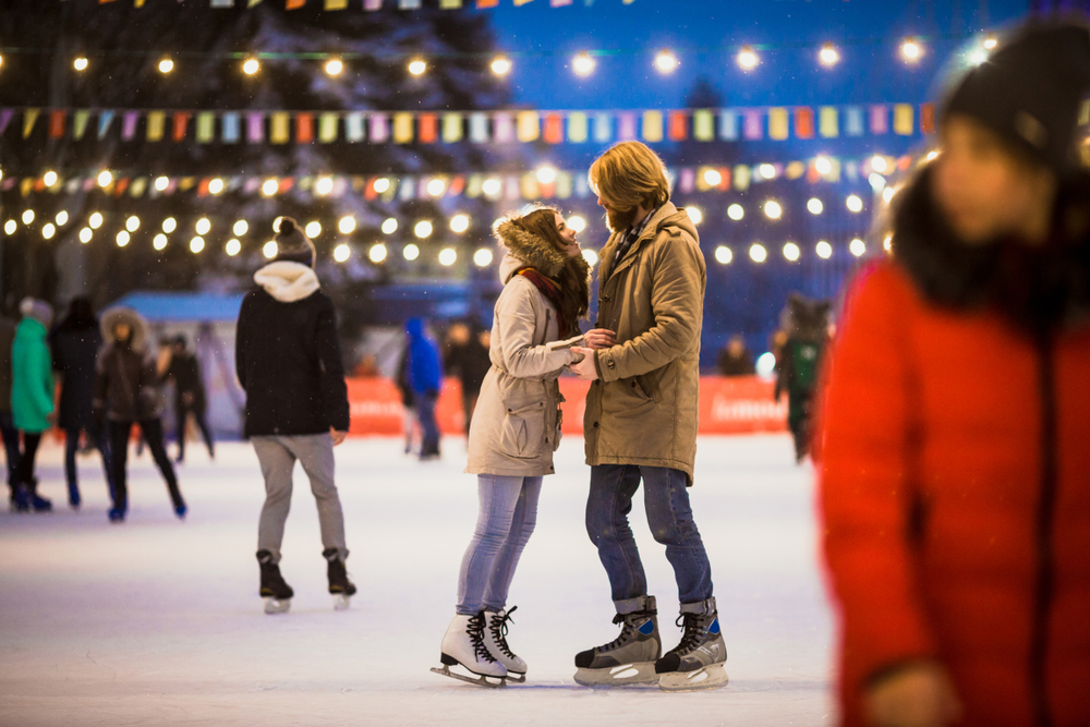 a couple ice skating in Baltimore md wearing warm coats 