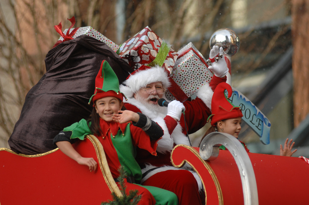santa and his elf helping on a christmas in balitmore parade 