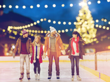Four friends ice skating at Enchant, a great activity for Christmas in Dallas!