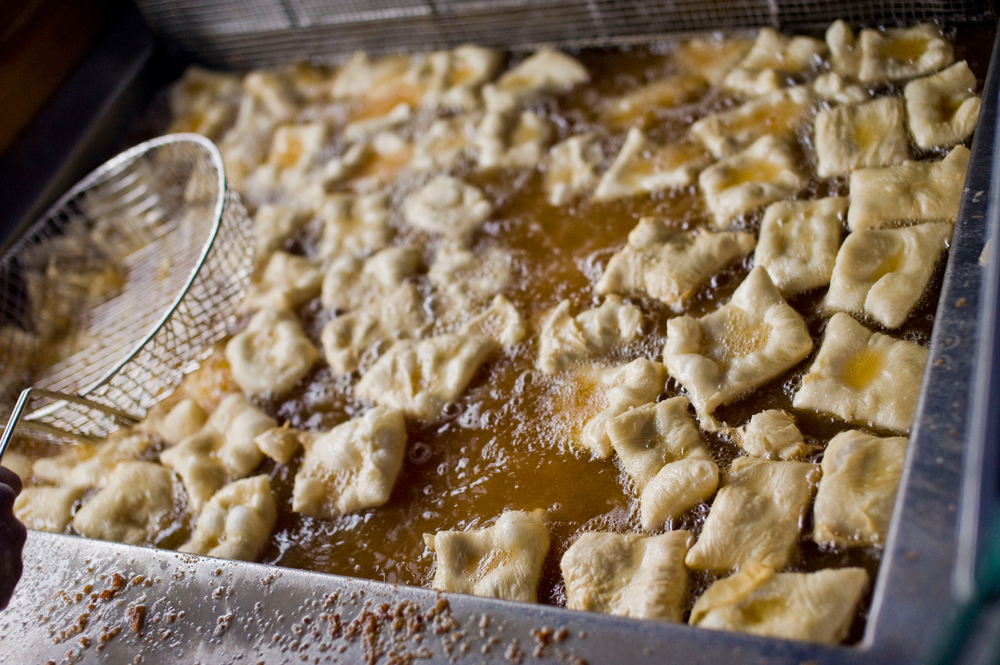 beignets cooking in oil at a christmas in new orleans festive event