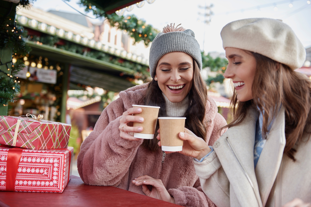 two women enjoying hot chocolate at the christmas Market in Savannah Ga