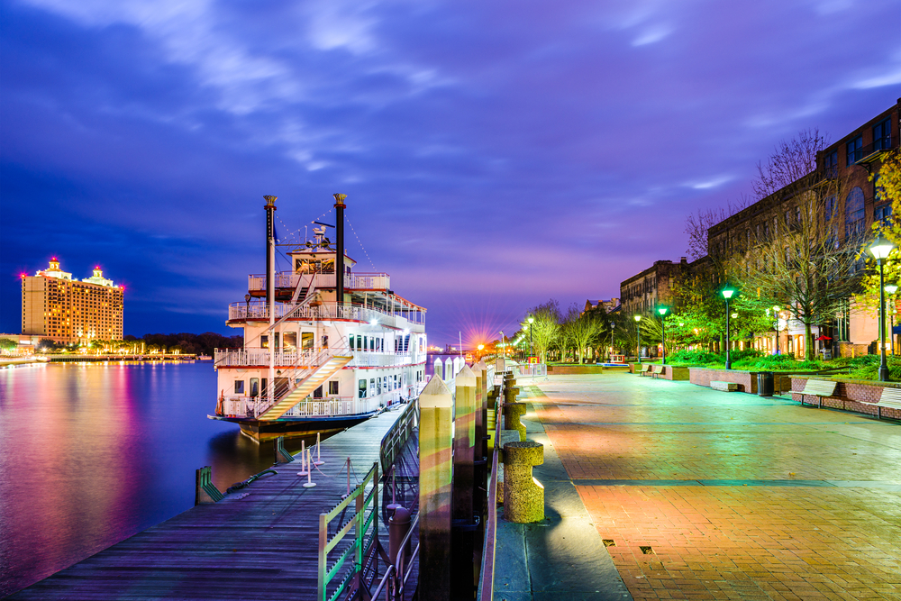 The waterfront in Savannah at dusk with the riverboat and street lights