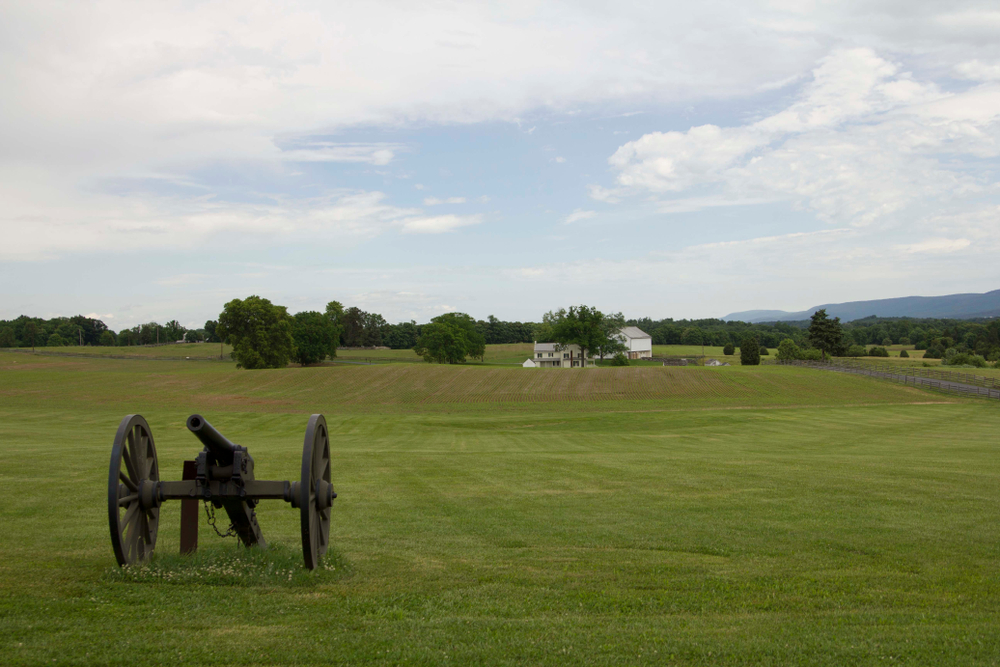 a civil war cannon in a large field during the day at the antietam battlefield, one of the best national parks in Maryland 