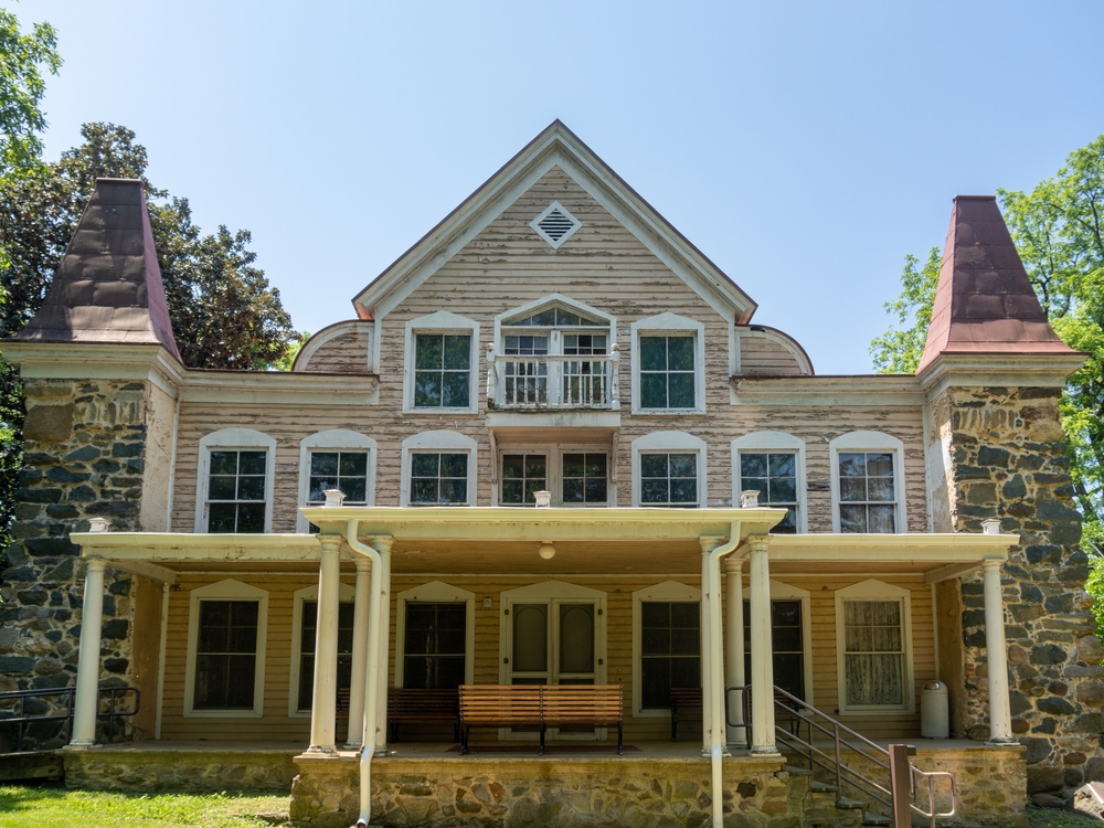 view of the Clara barton national historic site house from the front with views of the bench at the front door on a bright, sunny day 