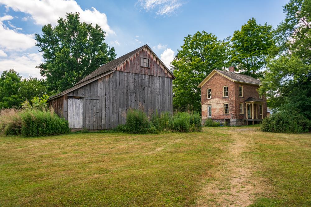 view of the Harriet Tubman Underground Railroad house and barn, one of the best national parks in Maryland, one a semi cloudy day surrounded by trees  