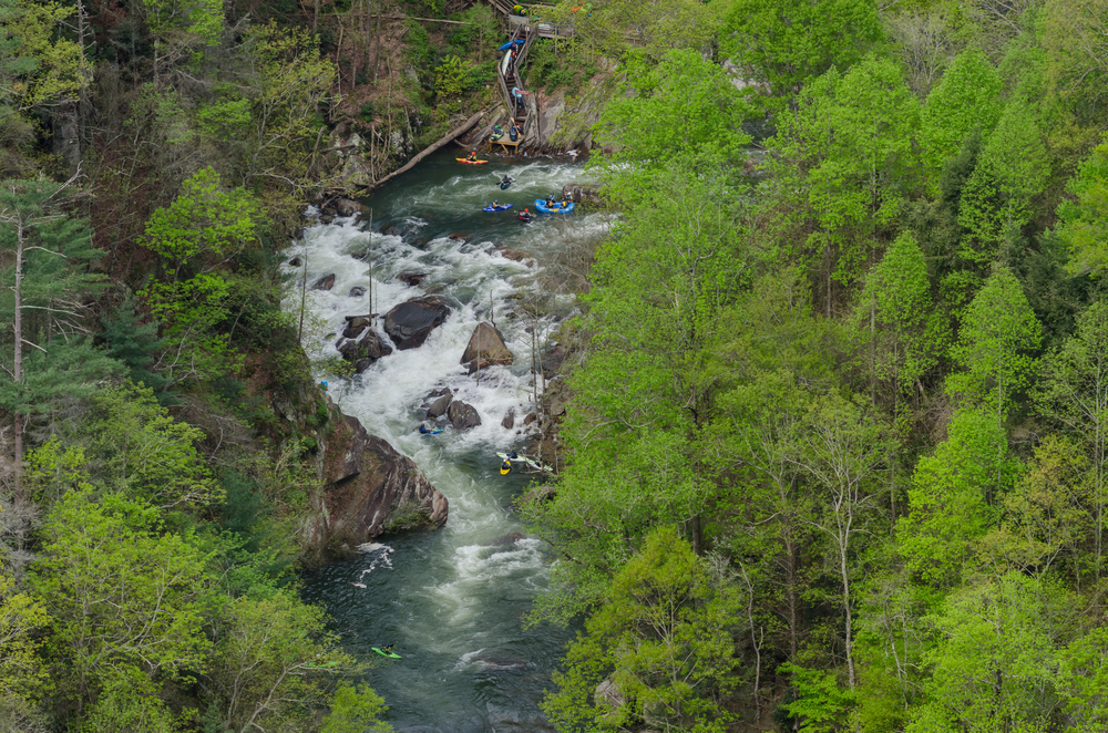 river through the middle of photo from top to bottom, people getting into the river from a staircase at the top of photo