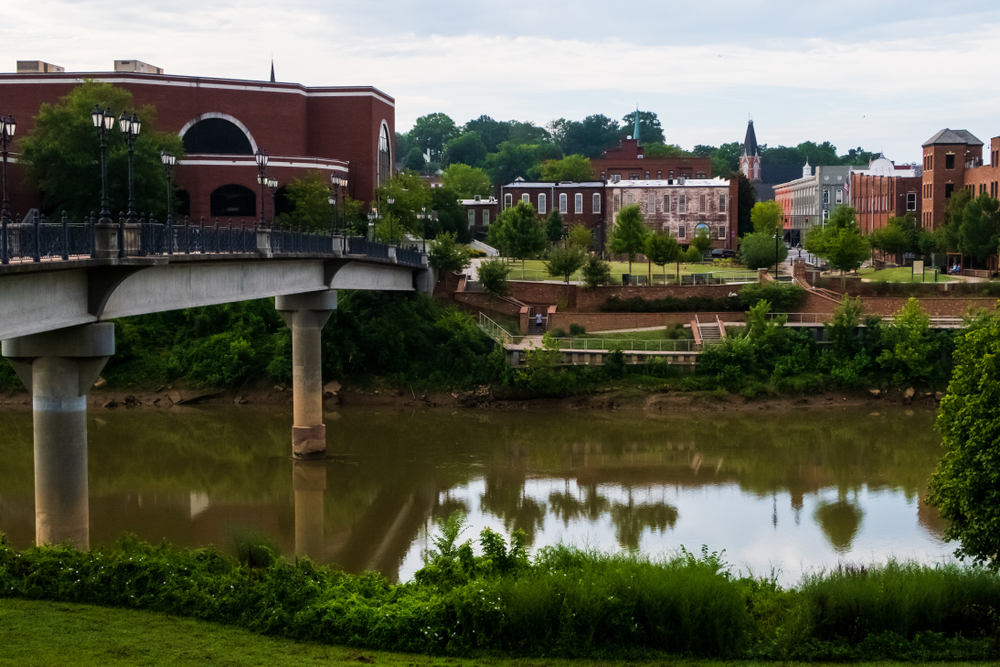 a bridge over the river with buildings in the background, rome GA, one of the best places for tubing in georgia