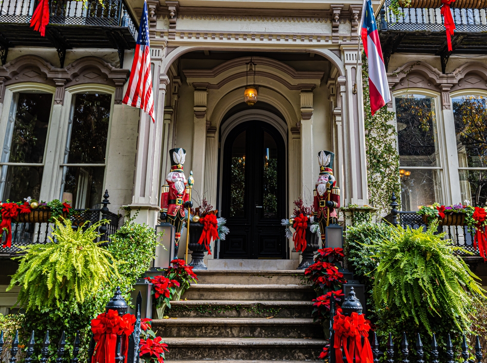 Nutcrackers and poinsettias line the front steps of a historic home in Savannah, one of the best Christmas towns in Georgia.