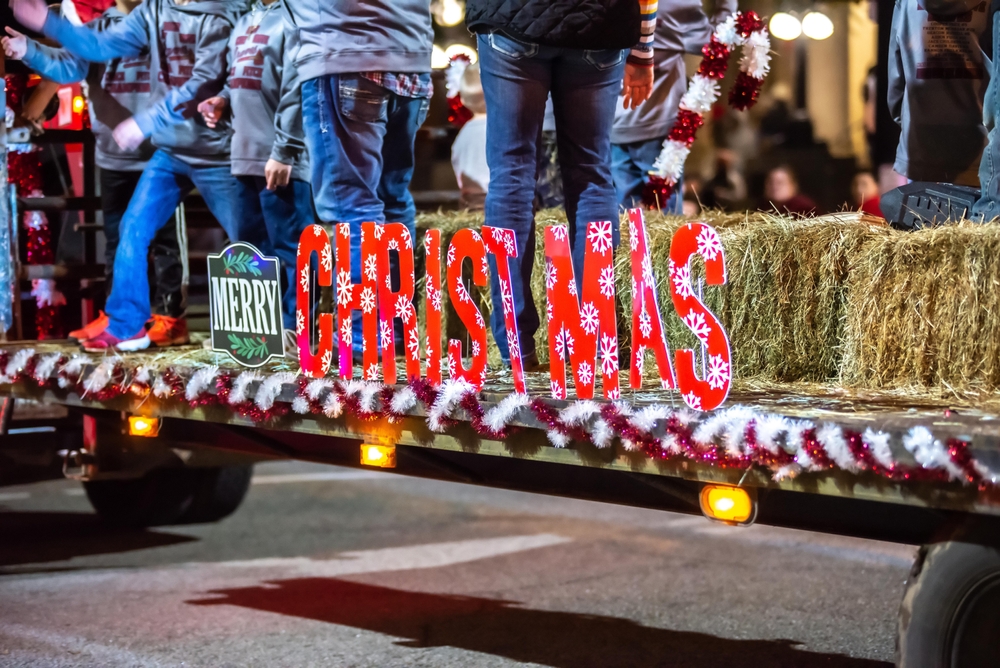 A float in the parade at Spartanburg, one of the best Christmas towns in South Carolina. The float has hay bails, garland, and a Merry Christmas sign.