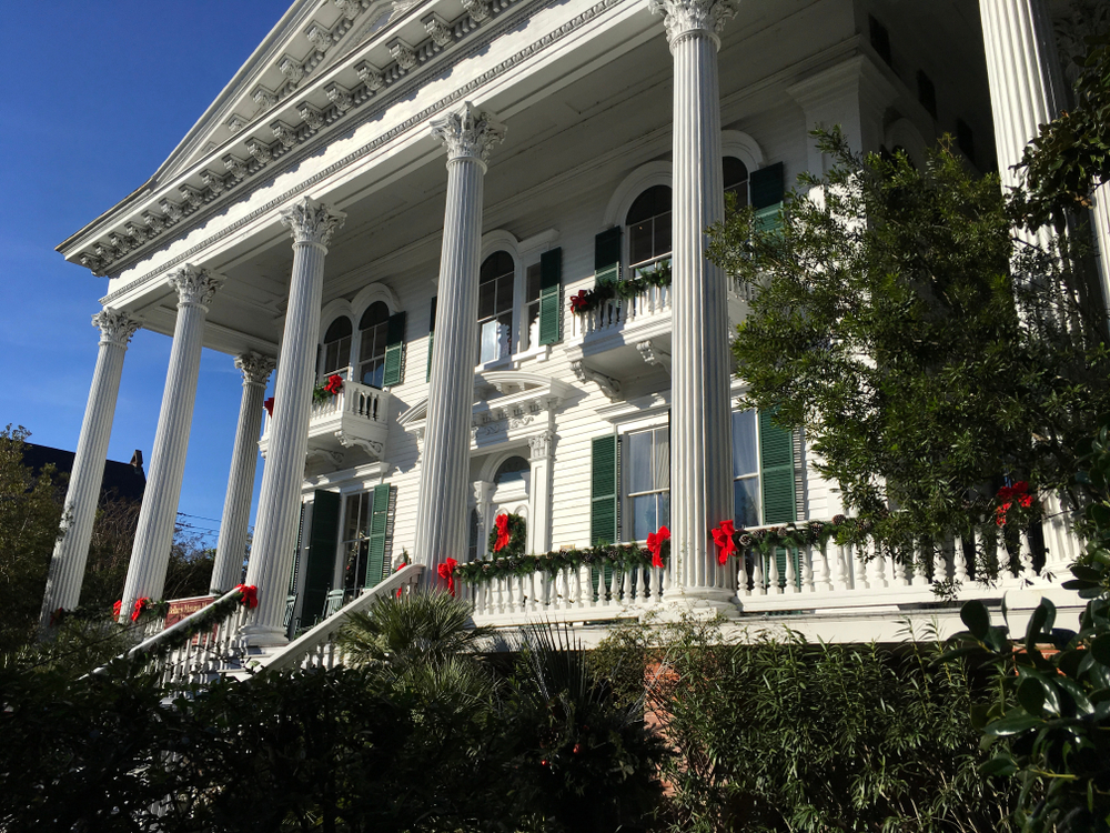 a historic home in wilmington nc that is decorated with garland and bows for christmas