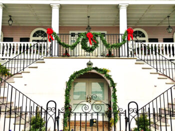 building in Historic Charleston that is decorated with wreaths and red ribbons