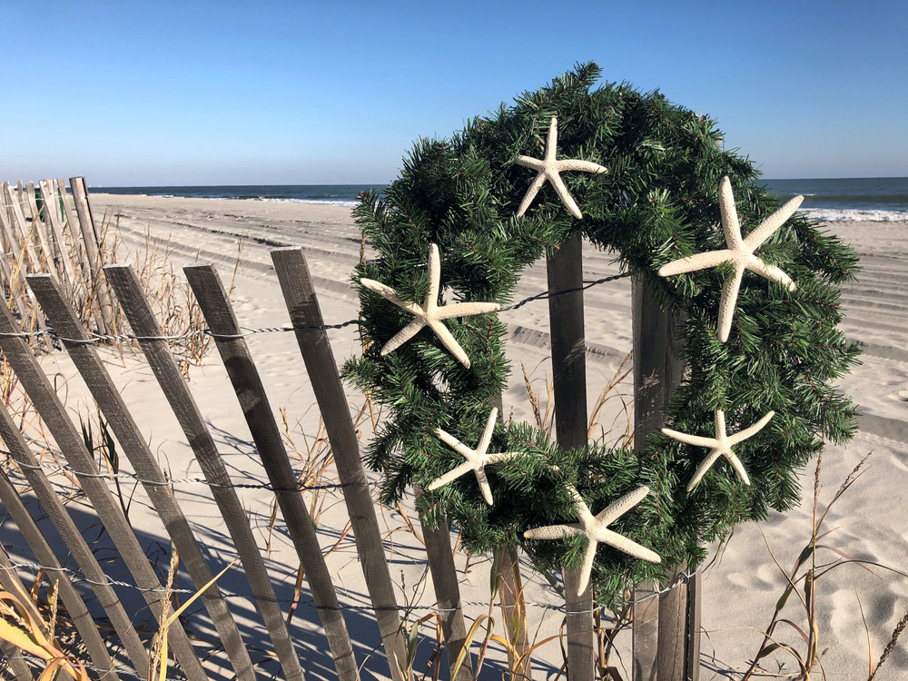 Christmas wreath with white starfish hanging on a fence in front of Myrtle Beach, one of the best Christmas towns in South Carolina.