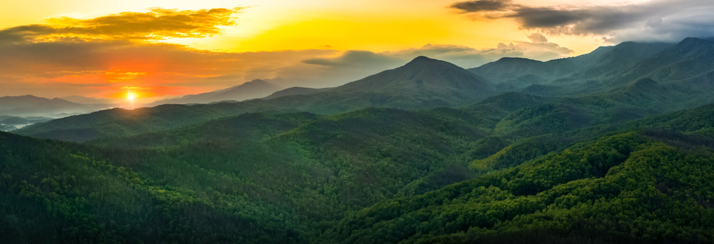 sunset over foggy mountains of lush green trees at one of the best east coast national parks!
