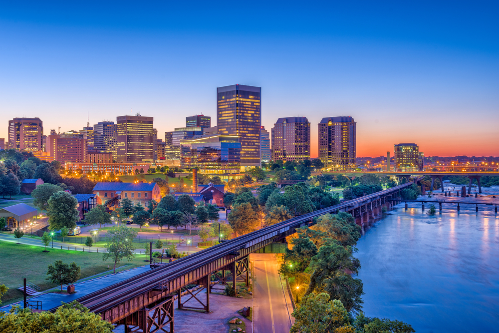 a picture of richmond, va at dusk! buildings and streets lit up with lights as darkness pulls down over the city, bright colours and beautiful atmosphere - things that make living in Virginia great!