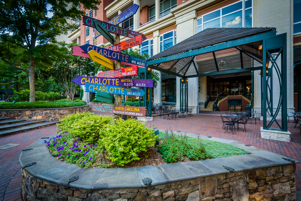 Distance signs at The Green, in Uptown Charlotte, North Carolina. The article is about living in North Carolina. 